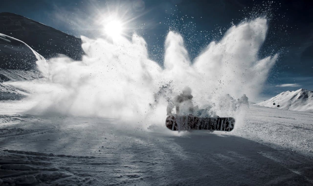 Snowboarder carving through powder